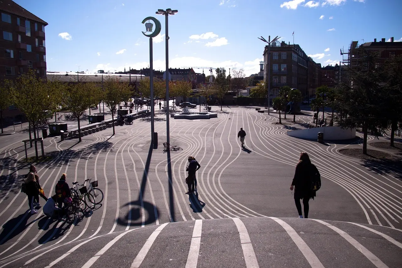 Fodgængere på en københavnsk plads med hvide linjer i belægningen