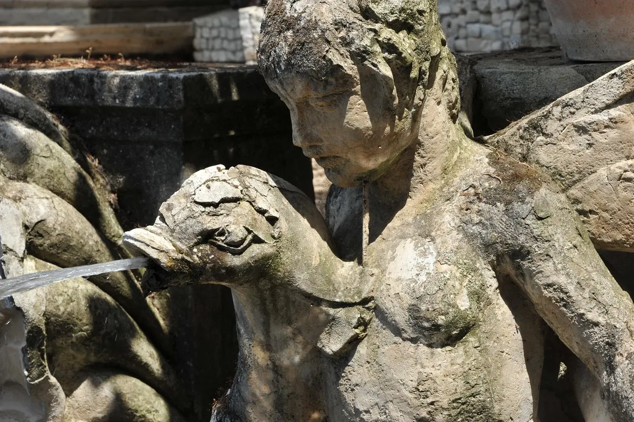 Detaljer i en slidt stenskulptur i et springvand